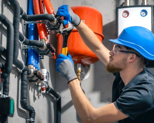 man-installs-heating-system-house-checks-pipes-with-wrench_169016-55834 man-installs-heating-system-house-checks-pipes-with-wrench_169016-55834